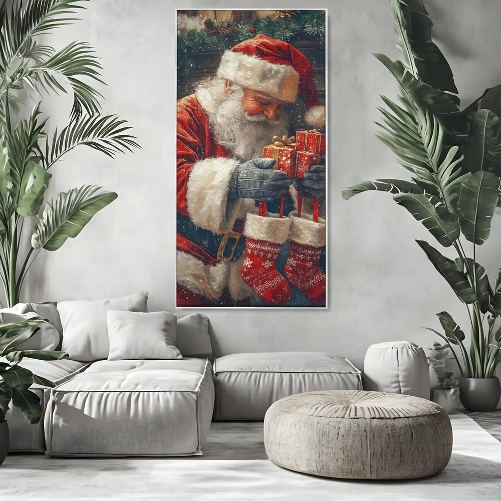 Tablou canvas cu ilustratie cu mos craciun tinand cadouri, in rama de aluminiu argintiu, pe perete intr-un living